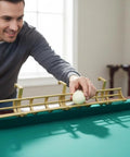 Man using Solid Gold Billiard Ball Rack And Pool Organizer Tray Wall Mount Storage Holder to place a ball on a pool table.