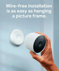 Person installing Nest Cam Outdoor Or Indoor Battery 2nd Generation 2 Pack with Extra Replacement Cable, demonstrating easy setup.