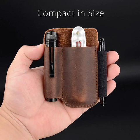 Hand holding compact full grain leather pocket organizer, chestnut color, with knife holder and pen loop, everyday carry.