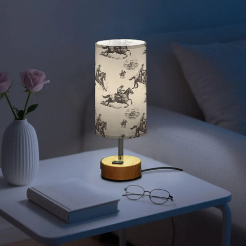 Cowboy Watercolor Decor Bedside Lamp With 3-Way Dimmable Touch Control And Built-In Charging Station next to vase and book on nightstand