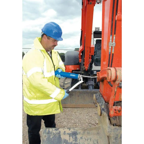 Worker uses Heavy Duty 500 CC Lever Grease Gun For Bulk Or Cartridge Loading on industrial equipment, hydraulic connector visible.