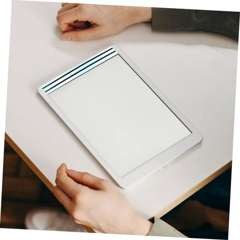 Person holding a tablet on a desk, illustrating the use of Dual Sided LCD Screen Repair Tape 10 Pack For Laptop And Phone Battery Removal