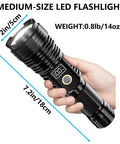 Medium-size Beast Bright Rechargeable Flashlight With 100,000 Lumens LED, zoomable torch with LCD display held in hand.