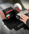 Badass Compact Desktop Electric Belt Sander Set For Sharpening Knives with an adjustable speed setting on a workbench.