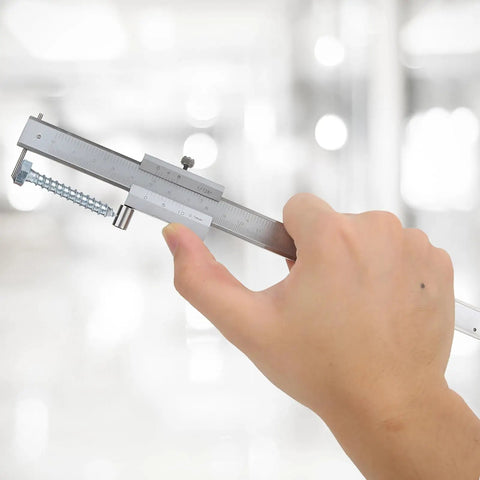 Rock Solid Eight Inch Stainless Scribe Calipers With Replaceable Carbide Tip measuring a screw, showcasing dual scale readouts.