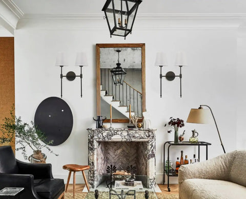Classic Rustic Double Wall Sconce Lighting Fixture With Flared White Textile Shade And Black Long Arm For Bedroom Bathroom And Hallway displayed in a living room setting above a fireplace.