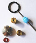 Top-down view of waterjet on/off valve repair kit; 7-piece set with metal shaft, blue spacer, brass discs, red and black O-rings.