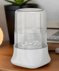 Portable Underwear Washer Mini Compact Laundry Device Built In Rechargeable Battery on a desk near a plant and lamp.