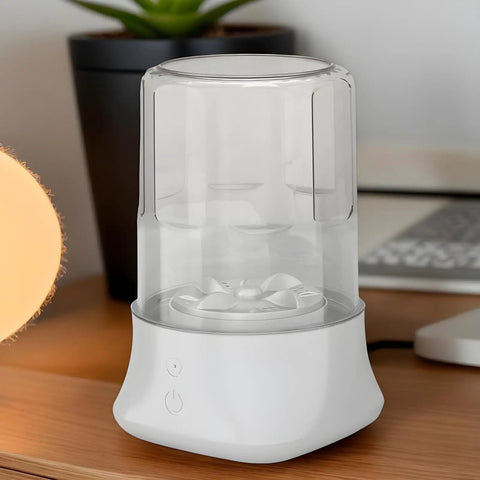 Portable Underwear Washer Mini Compact Laundry Device Built In Rechargeable Battery on a desk near a plant and lamp.