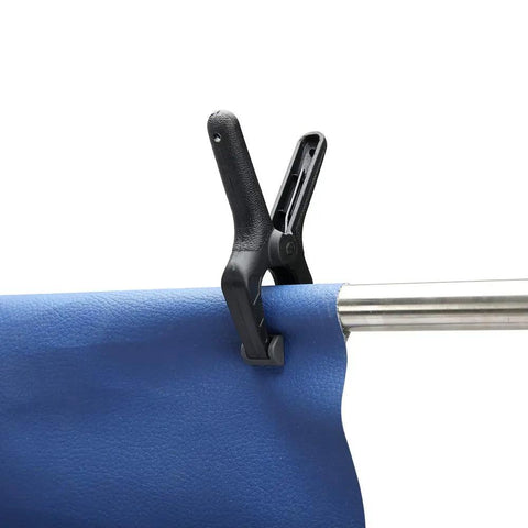 Black and grey clamp from 14 Piece Nylon Spring Clamp Set For Photography, Woodworking And Crafts holding blue fabric on rod