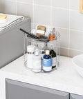 Totally Slick No Hassle 360 Spin Vanity Organizer Two Tier Clear Acrylic Rotating Storage for perfume and lotion on a countertop.