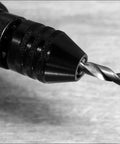 Close-up of black 1/4 Inch Hex Shank Keyless Drill Chuck Quick Change Adapter Converter For Impact Drills with drill bit inserted.