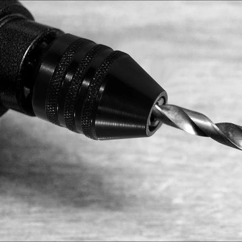 Close-up of black 1/4 Inch Hex Shank Keyless Drill Chuck Quick Change Adapter Converter For Impact Drills with drill bit inserted.