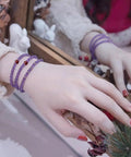 Woman's hand wearing purple bracelet with Approximately 270 Pieces 3mm Natural Faceted Garnet Beads For Jewelry Making.
