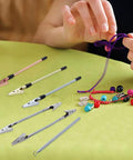 Six Piece DIY Bracelet Helper Kit With Clips And Hook For Self Wear displayed with hand using clip to fasten jewelry, gold, silver, rose gold.
