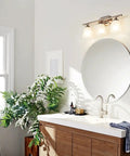 Bathroom with Ansonia 23-Inch Three Light Vanity Fixture With Satin Etched Glass And Brushed Nickel Finish above mirror