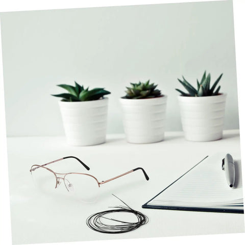 Eyeglasses Repair String For Half Frame Glasses Easy Quick Fix Tool on a desk with open notebook and potted plants in the background