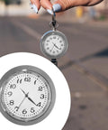 Close-up of Clock Insert Kit 1-7/16 Inch Dial Fits 1-3/8 Inch Hole with white dial and black numerals, held by hand