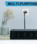 Six Pack US To Europe Plug Adapters Type C Travel Converter plugged into European wall outlet near speaker and vase
