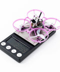 Ultra Light Brushless Whoop Quadcopter With Matrix 5IN1 II Flight Controller on scale weighing 20.9g, 1614-3B Props visible