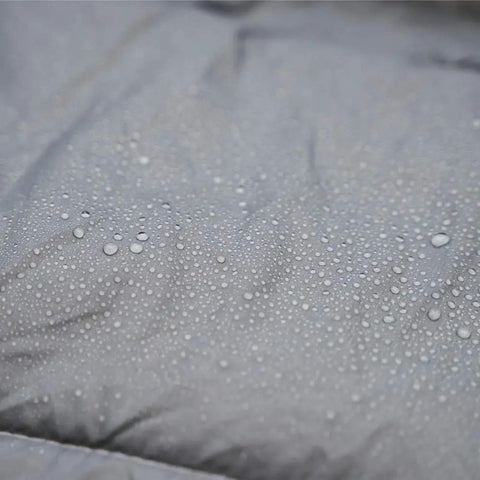 Close-up of the Ultralight Hammock Underquilt's water-resistant surface showing droplets on ripstop nylon material.