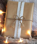 Brown gift wrapped with Heavy Duty Brown Jute Twine 328 Feet 2.5mm 4 Ply String, surrounded by string lights.