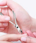 Person using stainless steel trimmer from 5 In 1 Cuticle Care Kit With Stainless Steel Trimmer Pusher Nipper Dead Skin Fork And Triangle Nail Scraper