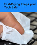 Close-up of a hand wiping a keyboard with a white cleaning towelette.