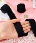 Polycotton Denim Fringe Ribbon 1 Inch Wide Raw Edged 4 Yards Pack For DIY Jewelry held over lace fabric on pink background