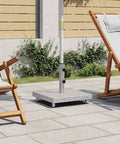 Granite and stainless steel tube parasol base with wheels in patio setting, easy mobility and quick positioning, gray outdoor stand with chairs.