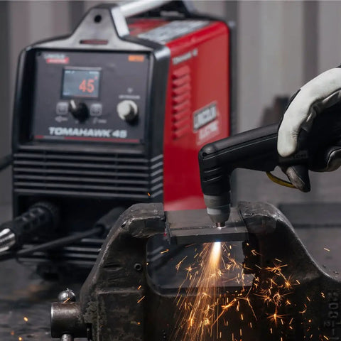 Lincoln Tomahawk 45 Handheld Plasma Cutter With 2.8 Inch LCD Screen cutting metal, sparks flying in workshop scene.