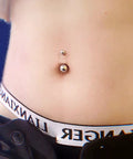 Close-up of a belly button with silver jewelry from 84 Piece Body Piercing Kit With 14G And 16G Jewelry For Nose Tongue Lip Ear Eyebrow