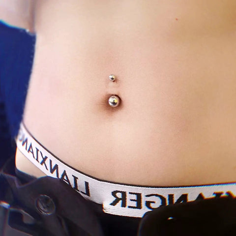 Close-up of a belly button with silver jewelry from 84 Piece Body Piercing Kit With 14G And 16G Jewelry For Nose Tongue Lip Ear Eyebrow