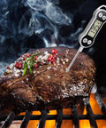 Ultimate Digital Meat Thermometer For Cooking And Grilling Instant Read Probe in steak on grill with temperature display