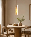 Alabaster Pendant Light Natural Marble Long Tube Hanging Lights with Wood Ceiling Canopy Modern Nordic Mini Pendant Lamp for Kitchen Island Bedroom Hallway(25 * 6cm) above a round wooden dining table.