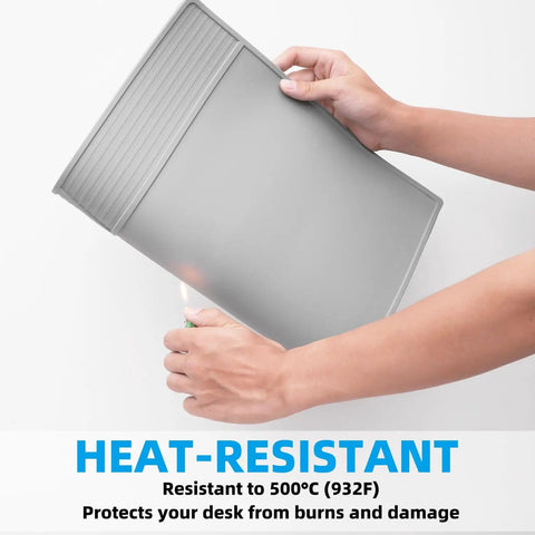 Person holding Gray Soldering Mat Heat Resistant 932 Fahrenheit With Scale Ruler And Screw Position Markers, showing heat resistance.