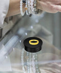 Electric Rotating Jewelry Display Stand showcasing a gold ring on a black turntable, with a hand in the background.
