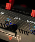 Boxer Max Transmitter Remote with Carbon Fiber Pattern Case showing headphone, USB-C, and trainer ports