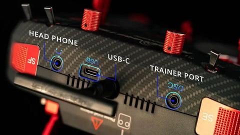 Boxer Max Transmitter Remote with Carbon Fiber Pattern Case showing headphone, USB-C, and trainer ports