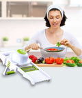 GProMe white mandoline slicer with green accents on kitchen counter beside fresh vegetables.