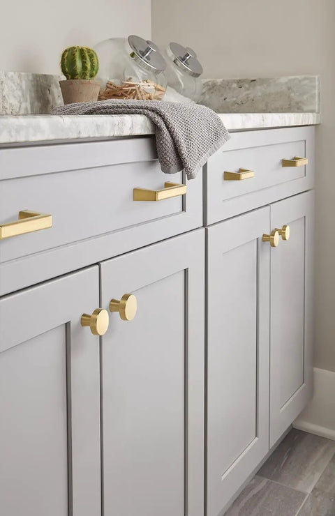Champagne Bronze Cabinet Knob for Drawers and Cabinets, 1-5/16 Inch Diameter (33mm) on light gray cabinetry in a bathroom setting