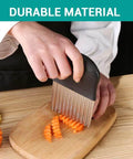 Front view of black-handled stainless steel crinkle cutter slicing carrot sticks on a wooden cutting board