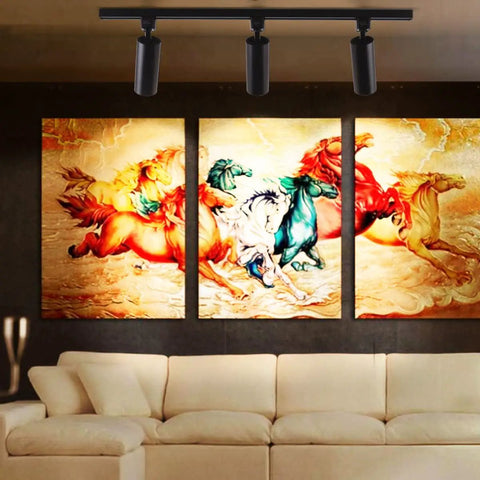 Six Pack 16.5W Dimmable LED Track Lighting Heads, 1200lm Each, illuminating artwork on a black wall above a beige sofa.