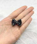 60Pc Glossy Black Disco Ball Beads With Sparkly Rhinestone on hand, showcasing shimmering bow design for DIY crafting.