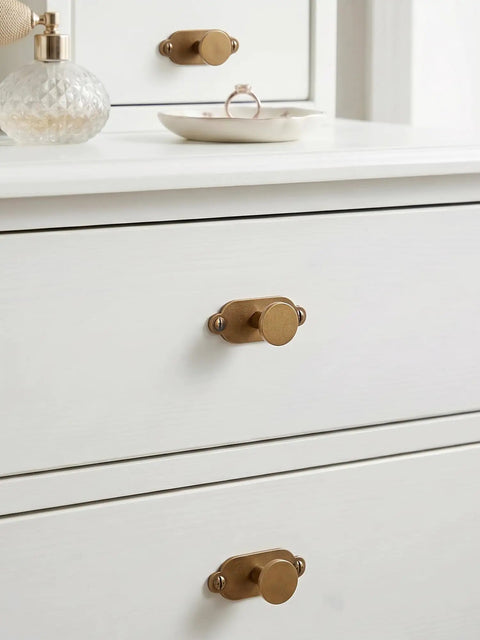 Premium Antique Brass Cabinet Knobs Paired With Elegant Oval Backplates 6 Pack on white dresser drawers.