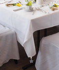 Table with Eight Ounce Tablecloth Weights With Stainless Steel Clips For Outdoor Tables Stay Put Windproof Patio And Picnic Setup Rust Resistant Stone Weights To Keep Cloth Flat In Gusty Weather Gray, featuring gray star-shaped clip on white tablecloth.