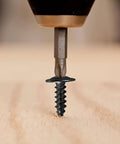Eight By One And One Half Inch Black Truss Head Wood Screws Self Tapping Zinc Oxide Coating being installed in wood
