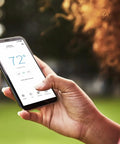 Smart Thermostat T5 Black ENERGY STAR Certified Cut Bills With Easy Temperature Control app on smartphone in hand outdoors
