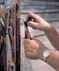 Hands using Heavy Duty Carbide Blade Scraper With 2.5 Inch Wide Blade, Ergonomic Handle on rusty metal railing.
