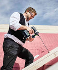 Heavy Duty Brushless Cordless Drill And Driver With Unbreakable Gears And 18 Volt Battery in use on a construction site.